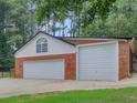 Large detached garage with two garage doors and ample parking space at 219 Riverbrook Ct, Mcdonough, GA 30252