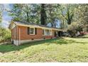 Quaint brick house surrounded by lush greenery and mature trees at 856 Glenway Dr, East Point, GA 30344
