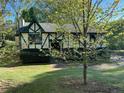 Quaint Tudor-style home with green trim and a well-maintained lawn and landscaping at 4152 Scenic Mountain Dr, Snellville, GA 30039