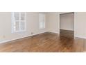 Bright living room featuring hardwood floors, neutral paint, baseboard trim and a view into the dining area at 1152 Old Coach Rd, Stone Mountain, GA 30083