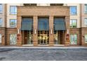 Close up of brick apartment building entrance with covered awning and glass doors at 711 Cosmopolitan Ne Dr # 213, Atlanta, GA 30324