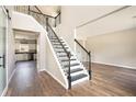 Bright foyer with hardwood floors, an open staircase and views of the kitchen with white cabinets at 8908 Brandy Rose, Douglasville, GA 30134