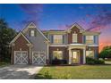 Charming two-story home with brick and gray siding, updated garage door, shutters and manicured front yard at 8908 Brandy Rose, Douglasville, GA 30134