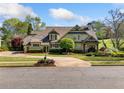 Charming two-story home with landscaped yard, circular driveway, and classic architectural details at 3018 Bradshaw Club Dr, Woodstock, GA 30188