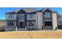 A luxury home with brick and stone and black windows complemented by manicured lawn at 3063 Reserve Ct Sw, Conyers, GA 30094