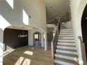 Grand foyer with hardwood floors, staircase with wood and iron banister, and arched doorway at 3063 Reserve Ct Sw, Conyers, GA 30094