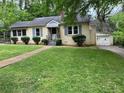 Single story home with a well-kept front lawn, charming facade and driveway leading to attached garage at 1604 Steele Nw Dr, Atlanta, GA 30309
