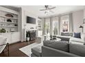 Open concept living room featuring a fireplace, built-in shelving, and large windows with natural light at 705 Abbington River Ln, Atlanta, GA 30339