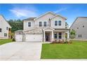 Charming two-story home with stone accents, a two-car garage and well-manicured front lawn at 719 Crossroad Ct, Powder Springs, GA 30127