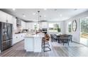 Well-lit kitchen with stainless steel appliances, island with seating, and an adjacent dining area at 719 Crossroad Ct, Powder Springs, GA 30127
