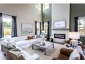Bright living room with fireplace, high ceilings, luxury furniture, and oversized windows at 719 Crossroad Ct, Powder Springs, GA 30127