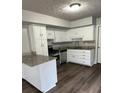 Well-lit kitchen with modern appliances, granite countertops, white cabinets, and wood flooring at 980 Fox Chase Ln, Riverdale, GA 30296