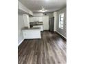 Open-concept kitchen with granite countertops, white cabinets, stainless steel refrigerator, and hardwood floors at 980 Fox Chase Ln, Riverdale, GA 30296