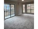 Bright and spacious living room with large windows, a sliding glass door, and new carpeting at 980 Fox Chase Ln, Riverdale, GA 30296