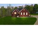 Charming red brick home featuring a well-manicured lawn and lovely landscaping at 896 Winn Rd, Douglasville, GA 30134