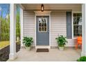Inviting front door with sidelight, planter boxes, and covered porch area at 10900 Wittenridge Dr # C1, Alpharetta, GA 30022