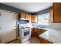 Traditional-style kitchen with white appliances, wooden cabinets, and a bright window at 1594 Lincoln Se Ave, Atlanta, GA 30317