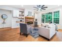 Cozy living room featuring a stone fireplace, built-in shelving, hardwood floors, and plenty of natural light at 5260 Moore St, Stone Mountain, GA 30083