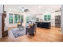 Open-concept living room with a stone fireplace, large windows, and hardwood floors at 5260 Moore St, Stone Mountain, GA 30083