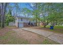 Charming two-story home with brick and light-colored siding, surrounded by mature trees and lush greenery at 616 Country Lane Dr, Jonesboro, GA 30238