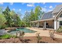 Backyard oasis with a pool, waterfall, and covered patio for outdoor entertaining at 2839 Echols Rd, Cumming, GA 30041