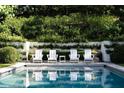 Relaxing pool with four chairs and greenery wall creating a private and serene outdoor space at 315 Peachtree Battle Nw Ave, Atlanta, GA 30305
