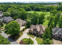 A beautiful aerial shot of a brick and stone home surrounded by lush greenery and a well-manicured lawn at 6935 Wakehurst Pl, Cumming, GA 30040