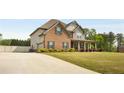 Two-story brick and siding home featuring manicured lawn, a long driveway and attached garage at 209 Brynn Ln, Mcdonough, GA 30252