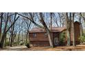 Charming house with wood siding, nestled among mature trees in a serene, wooded setting with stone foundation at 2763 Macby Walk, Marietta, GA 30066