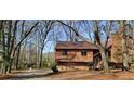 Charming house with wood siding, nestled among mature trees in a serene, wooded setting with stone foundation at 2763 Macby Walk, Marietta, GA 30066