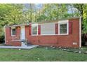 Traditional brick home featuring a front porch, red shutters, and green lawn at 299 Ard Nw Pl, Atlanta, GA 30331