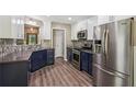Modern kitchen with stainless steel appliances, blue cabinets, and a mosaic backsplash at 7675 Rose Ln, Cumming, GA 30040