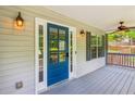 Covered porch with a blue door, ceiling fan, and view to the backyard at 7675 Rose Ln, Cumming, GA 30040