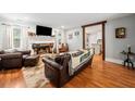 Open-concept living room with hardwood floors, fireplace, and rustic wood trim at 24 Scarlett Oak Ne Dr, Cartersville, GA 30121