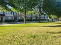 Neighborhood street with townhouses, mature trees, and well-manicured lawns at 5449 Festival Ave, Fairburn, GA 30213