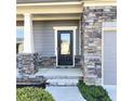 Inviting front entrance features a black door, stone accents, and a well-manicured walkway at 5990 Arbor Green Cir, Sugar Hill, GA 30518