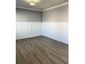 Bright room with hardwood flooring, gray accent walls, white trim, and ceiling light at 5990 Arbor Green Cir, Sugar Hill, GA 30518