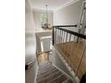 Carpeted staircase leading to the foyer with a chandelier and hardwood flooring visible at 125 Ketton Xing, Johns Creek, GA 30097