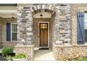 Inviting front door with a stone archway and elegant design in a brick surround at 403 Aristides Way, Canton, GA 30115