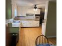 Traditional kitchen with white cabinets, hardwood flooring, and modern appliances at 9214 Brave Ct, Jonesboro, GA 30236