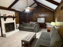 Spacious living room with vaulted ceiling, wood paneling, and a stone fireplace at 9214 Brave Ct, Jonesboro, GA 30236
