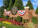 Elegant brick sign for Woodmont Golf and Country Club with patriotic bunting and landscaping at 135 Ardsley Run, Canton, GA 30115