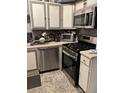 Kitchen featuring stainless steel appliances, tiled floors, and ample cabinet space at 3833 Brookstone Way, Ellenwood, GA 30294