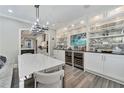 Elegant dining room with built-in cabinets, wine coolers, and a modern chandelier at 2444 Ballantrae Cir, Cumming, GA 30041
