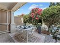 Outdoor patio with a dining set surrounded by lush greenery and colorful flowering plants at 2444 Ballantrae Cir, Cumming, GA 30041