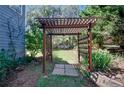 Wooden pergola structure in a backyard garden with a small grassy area at 35 Kestrel Circle, Covington, GA 30014
