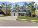 Charming two-story home with a three car garage and manicured lawn at 6655 Grove Meadows Ln, Cumming, GA 30028