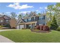 Charming two-story home with a three car garage and manicured lawn at 6655 Grove Meadows Ln, Cumming, GA 30028