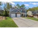 Charming two-story home with a three car garage and manicured lawn at 6655 Grove Meadows Ln, Cumming, GA 30028