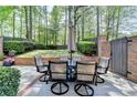 Outdoor patio with dining set, perfect for entertaining, surrounded by lush greenery and a privacy fence at 7512 Portbury Park Ln, Suwanee, GA 30024
